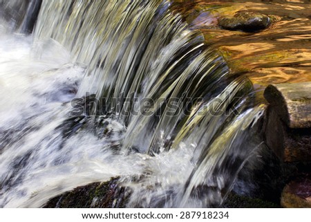 clean water flows through the wooden logs, falling cascade down