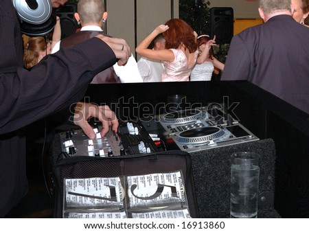 Disk jockey providing music at a wedding reception.