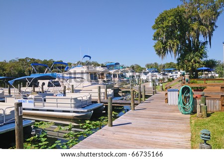 Pontoon boats and houseboats tied up at the marina,s dock in Deland, Florida.