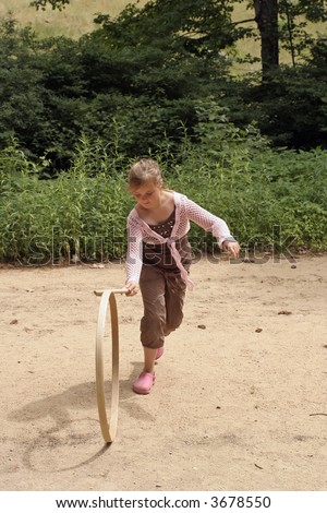 Girl in Hoop racing game, rolling hoop with a stick