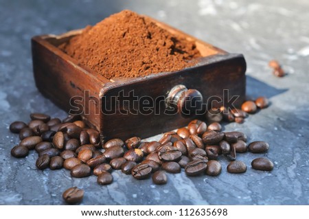 coffee beans and ground coffee in a small wooden drawer