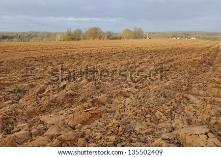 large land plowed field under a cloudy sky