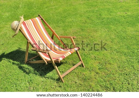 lounge chair and straw hat on sunny lawn