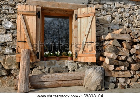 cottage of stone and wood with pile of firewood