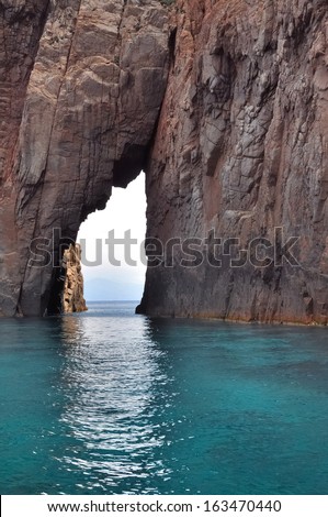 a passage through the rock in a turquoise sea