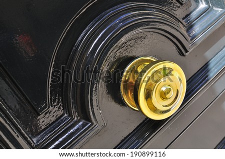 golden handle of a door painted black