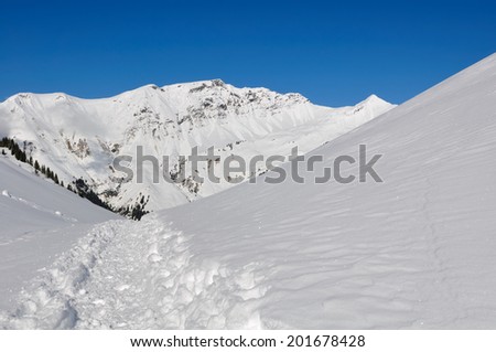 path in the snow through the snowy mountains