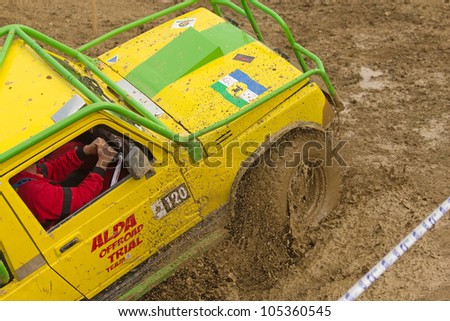MOHELNICE, CZECH REPUBLIC - JUNE 10. Unidentified racer at yellow off-road car leaves muddy puddle in the \