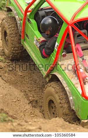 MOHELNICE, CZECH REPUBLIC - JUNE 10. Unidentified racer at green  off-road car leaves muddy puddle in the \