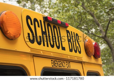Yellow back of school bus with a sign