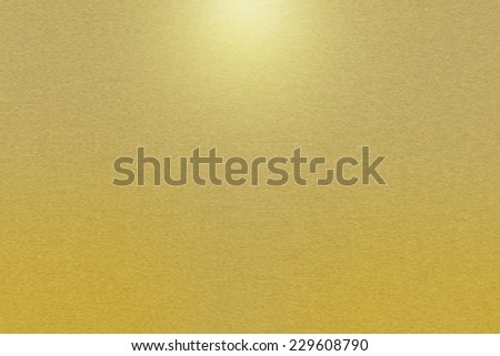 Pattern of brushed gold metal background. Subdued light is in the upper middle part of the background.