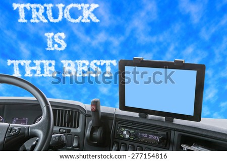Dashboard of the truck with sky in front of the car. The inscription TRUCK IS THE BEST is formed from clouds in the blue sky. Navigation display is colored in light blue and is ready for your text.