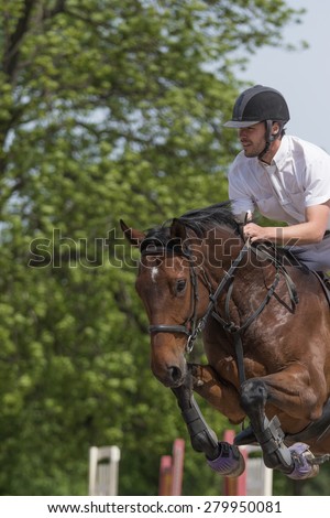TRESTINA, CZECH REPUBLIC - MAY 16: Closeup of horseman in white that is jumping on the brown horse at \
