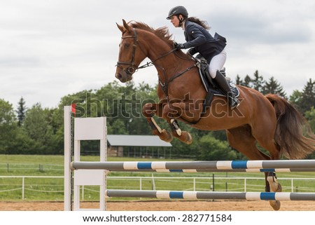 SVEBOHOV, CZECH REPUBLIC - MAY 23: Closeup view of young  horsewoman high jump over the hurdle at \