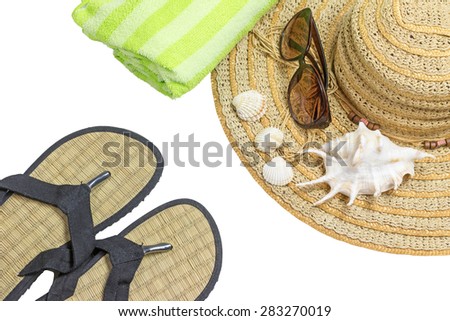 Straw hat, sunglasses, green towel  and seashells are on the right side of the photo. Beach sandals are in the lower left side of the photo.isolated. All potential trademarks are removed.