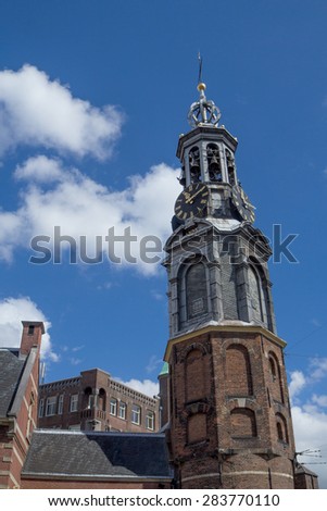 The Munttoren (Coin Tower) tower near the flower market in Amsterdam (Netherlands). Blue sky with clouds is in the background.