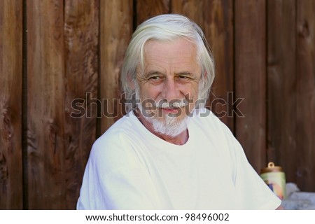 Good looking, smiling old gray man in a white T-shirt