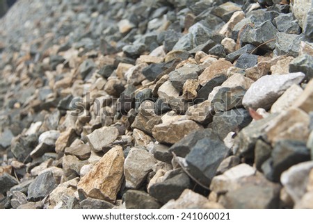 Many rocks on the ground near a siding railway.