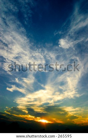 Sunset and blue sky with white clouds. Wide angle lens gives a sense of depth. Vertical format
