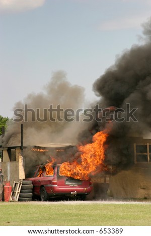 A car on fire with billowing black smoke