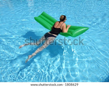 A woman on vacation relaxes in the pool on a summer day