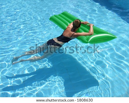 A woman on vacation relaxes in the pool on a summer day