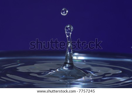 Genuine water drop impact with tower of water and droplet