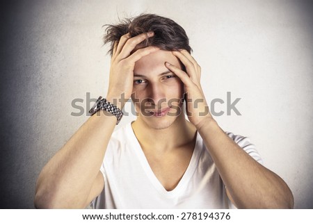 Stressed young man with hands on the head