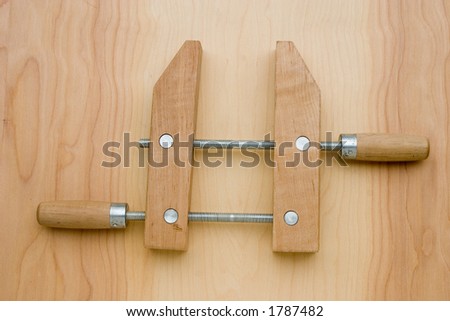 Wooden clamp on wood grain background