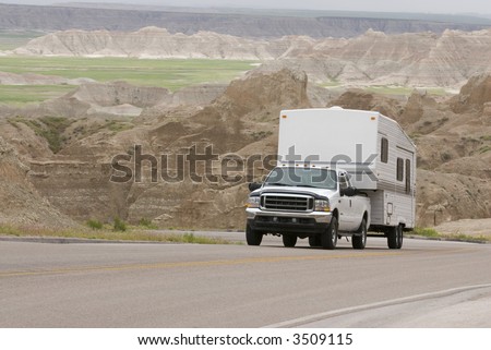 RV pick-up truck and trailer climbing scenic mountain road in the Badlands