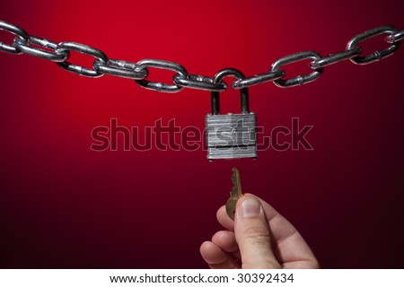 chain opening lock with key on red background