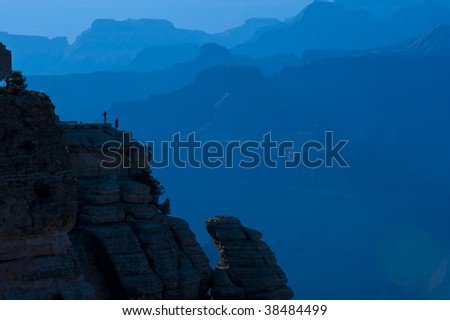 Tourist posing on cliff at Grand Canyon with blue background