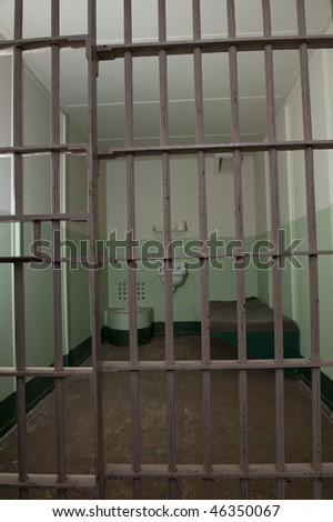 Stark prison cell with bed and toilet