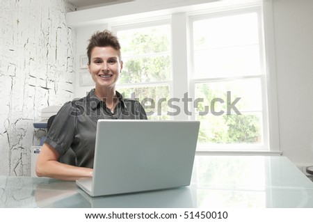 Beautiful female model at computer in bright office