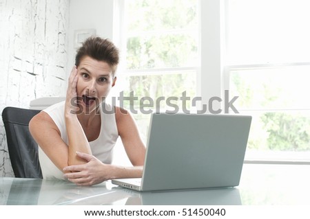 Beautiful female model at computer in bright office