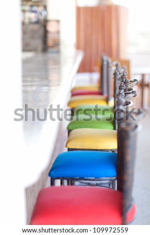 colorful bar stools at an empty bar