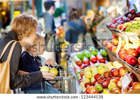 mother and her son buying fruits at a farmers market