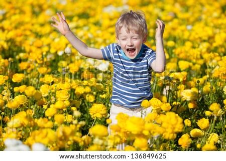 happy smiling kid jumping at the flower field