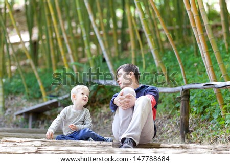happy family of father and son talking together at japanese garden