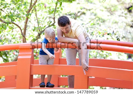 young father and his cute son spending time together in japanese garden
