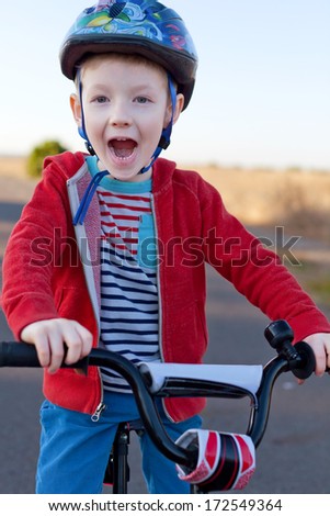 cute little boy riding the bike outside