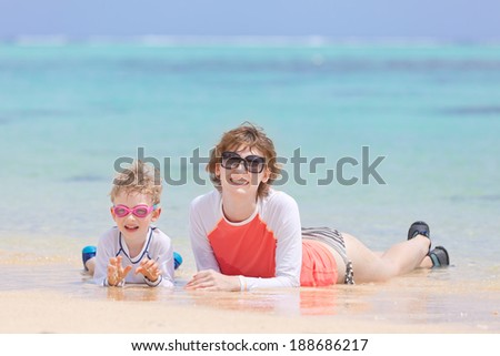 happy family of two lying at perfect beach during tropical vacation