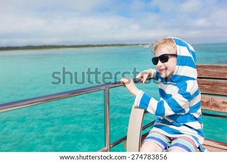 smiling boy enjoying boat ride in turquoise waters near taketomi island, okinawa, japan