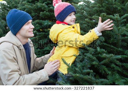 little smiling boy and his father shopping for christmas tree