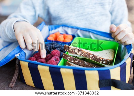 close-up of cheerful schoolboy eating healthy lunch outdoor