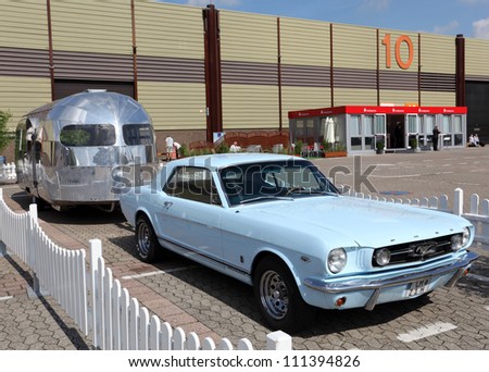 DUSSELDORF - AUGUST 27: Old Ford Mustang with an Airstream caravan at the Caravan Salon Exhibition 2012 on August 27, 2012 in Dusseldorf, Germany.