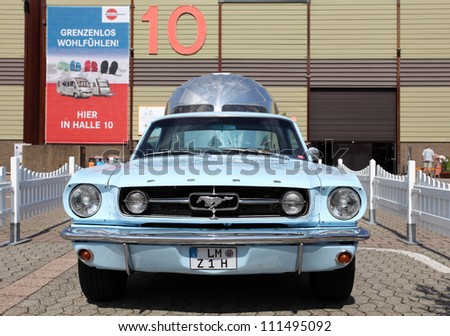 DUSSELDORF - AUGUST 27: Old Ford Mustang with an Airstream caravan at the Caravan Salon Exhibition 2012 on August 27, 2012 in Dusseldorf, Germany.
