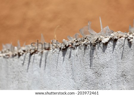 Glass shards on top of a wall