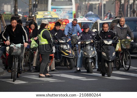 SHANGHAI, CHINA - NOV 20: Chinese people on bicycles and motorcycles in the city of Shanghai. November 20, 2010 in Shanghai, China