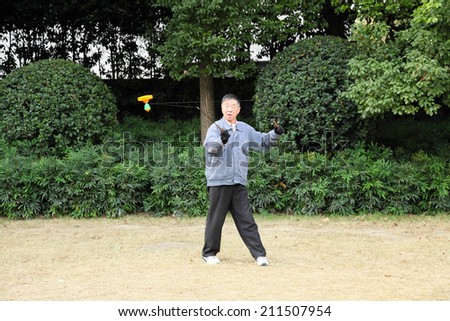 SHANGHAI, CHINA - NOV 23: Chinese man playing Yo Yo game in a park. November 23, 2010, in Shanghai, China